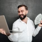 Portrait successful businessman white shirt holding fan money dollar banknotes silver notebook both hands dark gray